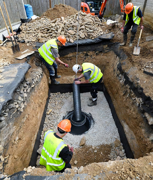 workmen constructing a soakaway