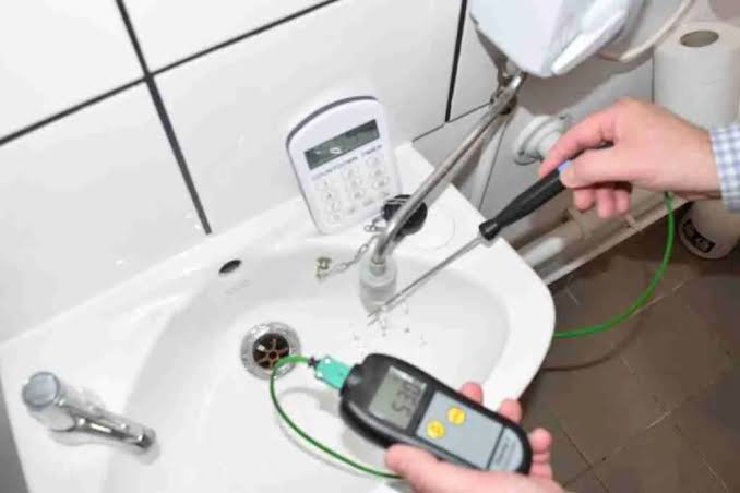 Engineer testing water for legionella bacteria Image
