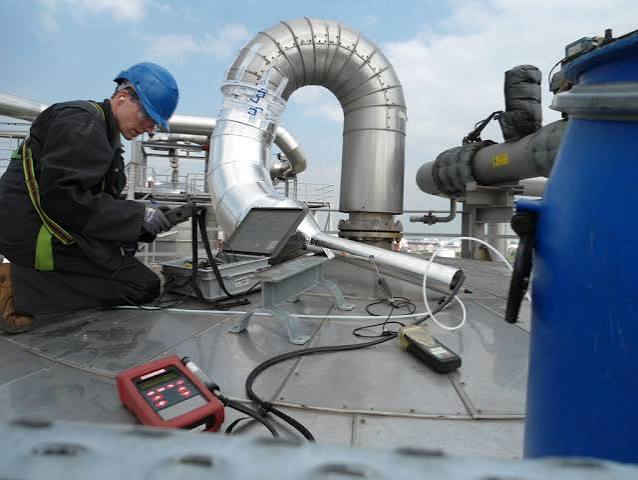 Odour engineers taking a sample from an extractor fan on a factory roof.